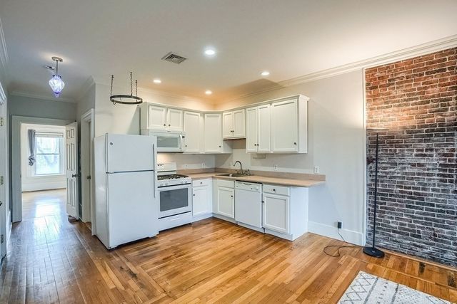 a kitchen with granite countertop white cabinets and white appliances