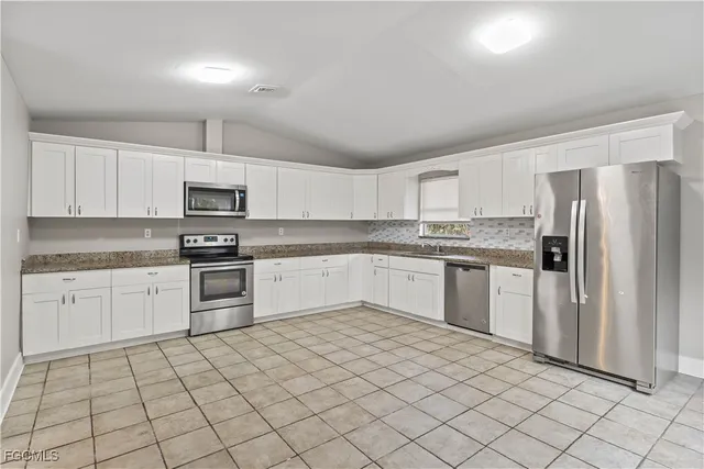 a kitchen with stainless steel appliances granite countertop a refrigerator sink and cabinets