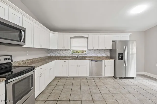 a kitchen with stainless steel appliances granite countertop a sink and a stove