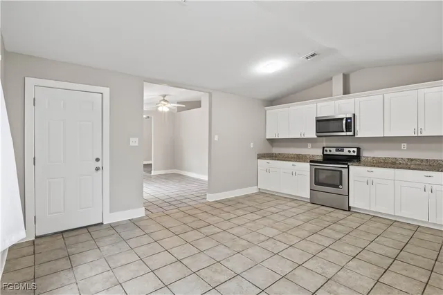 a kitchen with granite countertop white cabinets and stainless steel appliances