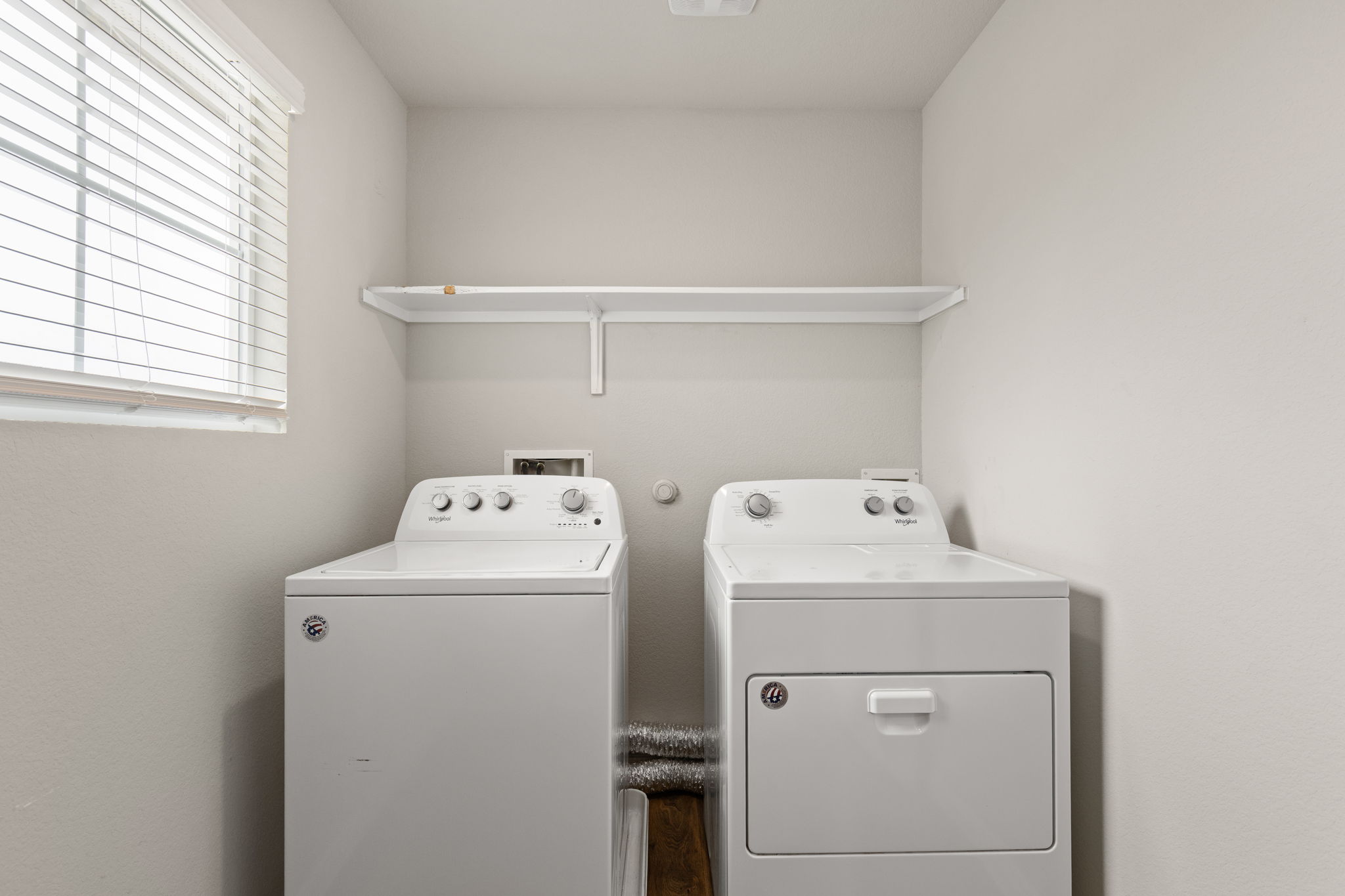 281 Jayden Drive Kyle, TX 78640 - Photo 28 of 36 Dedicated laundry area with light gray walls, a window with horizontal blinds, and a white storage shelf