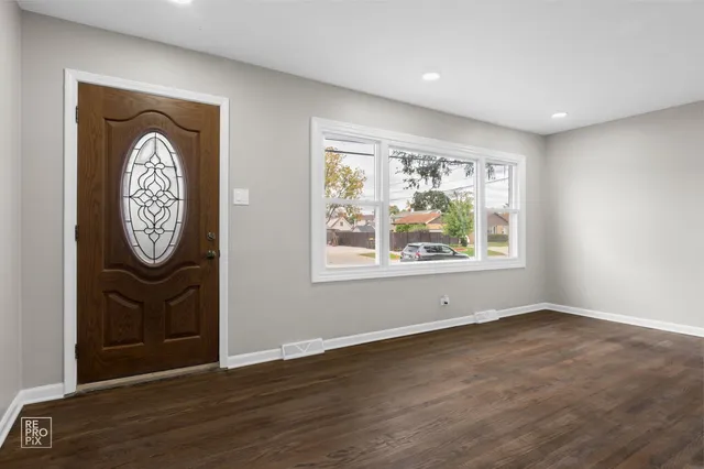 an empty room with wooden floor and a window