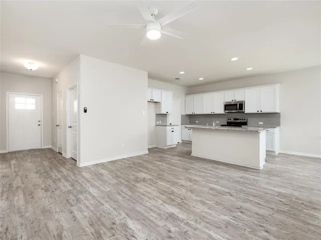 a view of kitchen with granite countertop cabinets and refrigerator