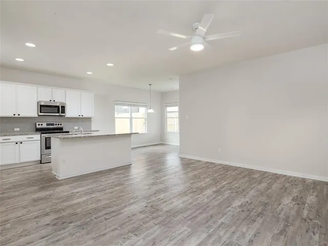 a view of kitchen with granite countertop cabinets and window
