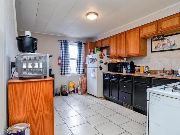 a kitchen with stainless steel appliances granite countertop a stove top oven a sink dishwasher and a refrigerator with wooden cabinets