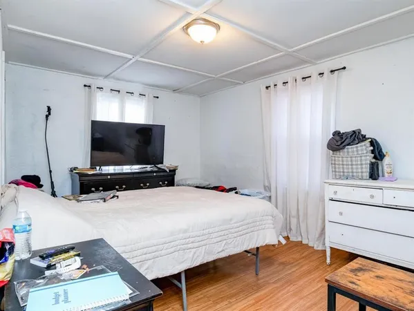 a bedroom with a bed and a flat screen tv