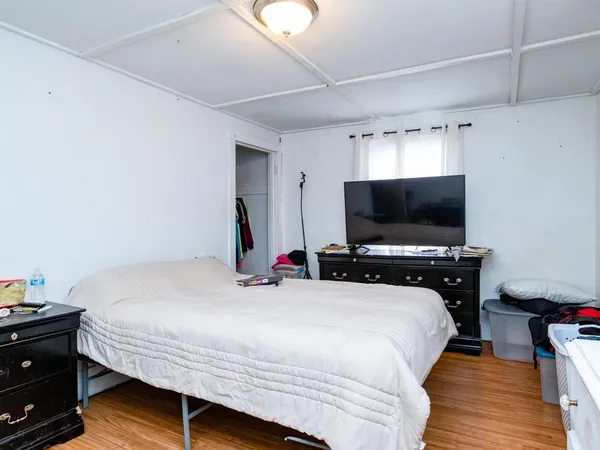a bedroom with a bed and a flat screen tv