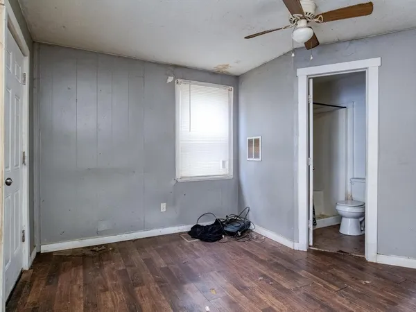 a view of a room with wooden floor and a ceiling fan