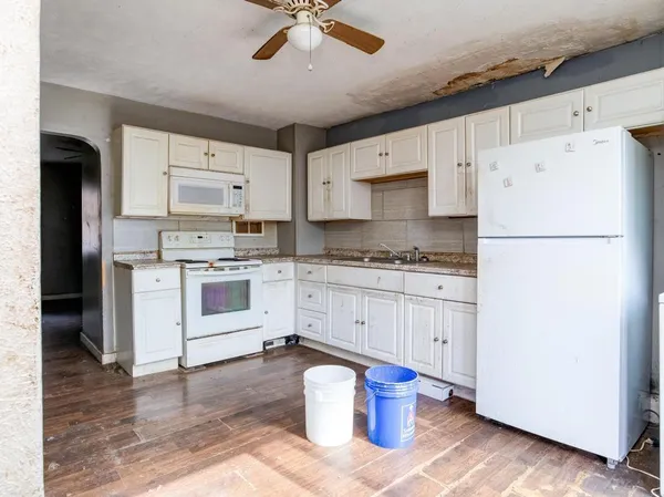 a kitchen with white cabinets and white appliances