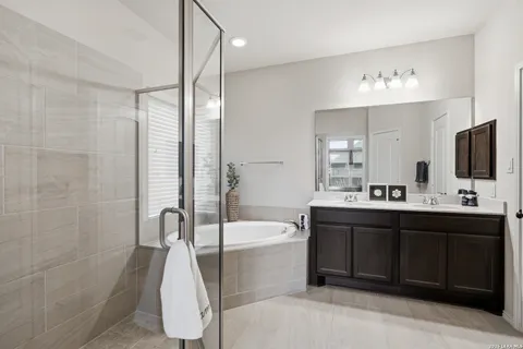 a bathroom with a tub sink and mirror