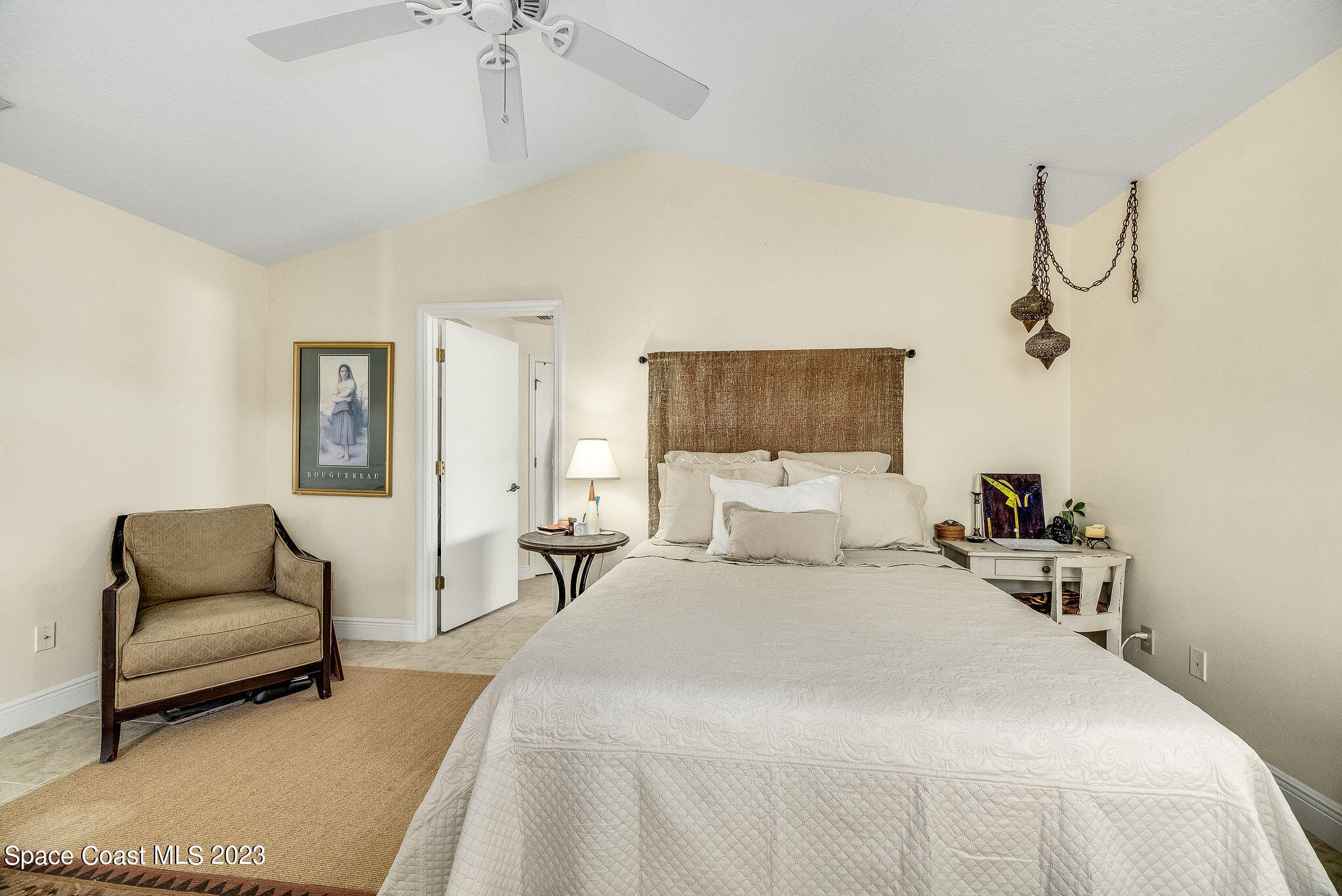 440 Maple Bluff Circle Melbourne, FL 32940 - Photo 39 of 92 a bedroom with a bed a couch and chandelier