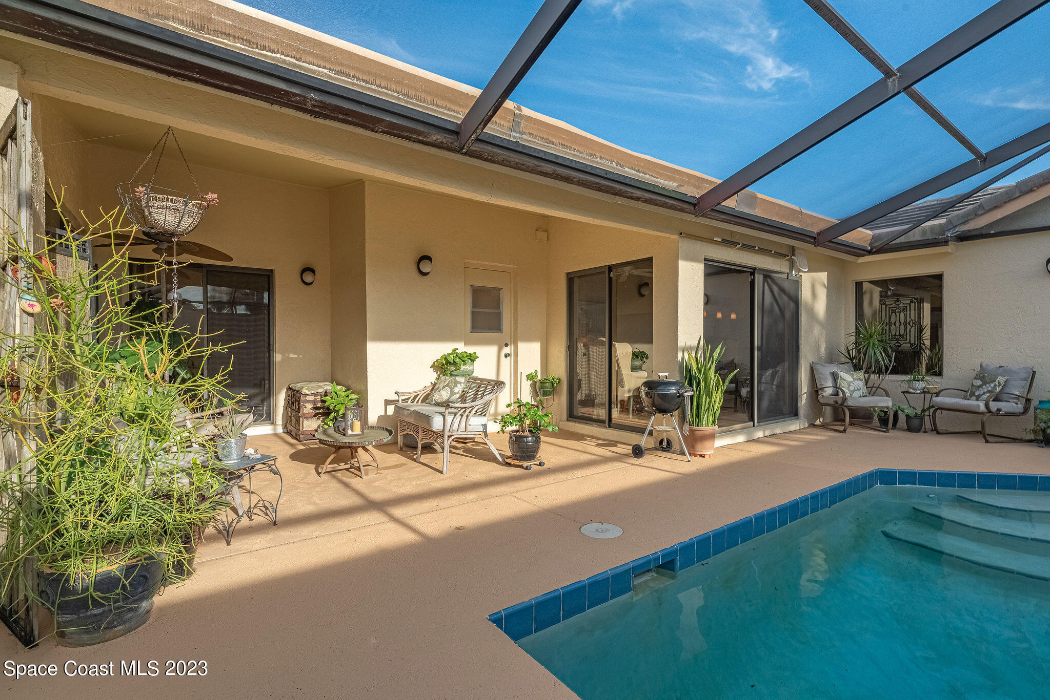 440 Maple Bluff Circle Melbourne, FL 32940 - Photo 44 of 92 a view of a patio with dining table and chairs under an umbrella
