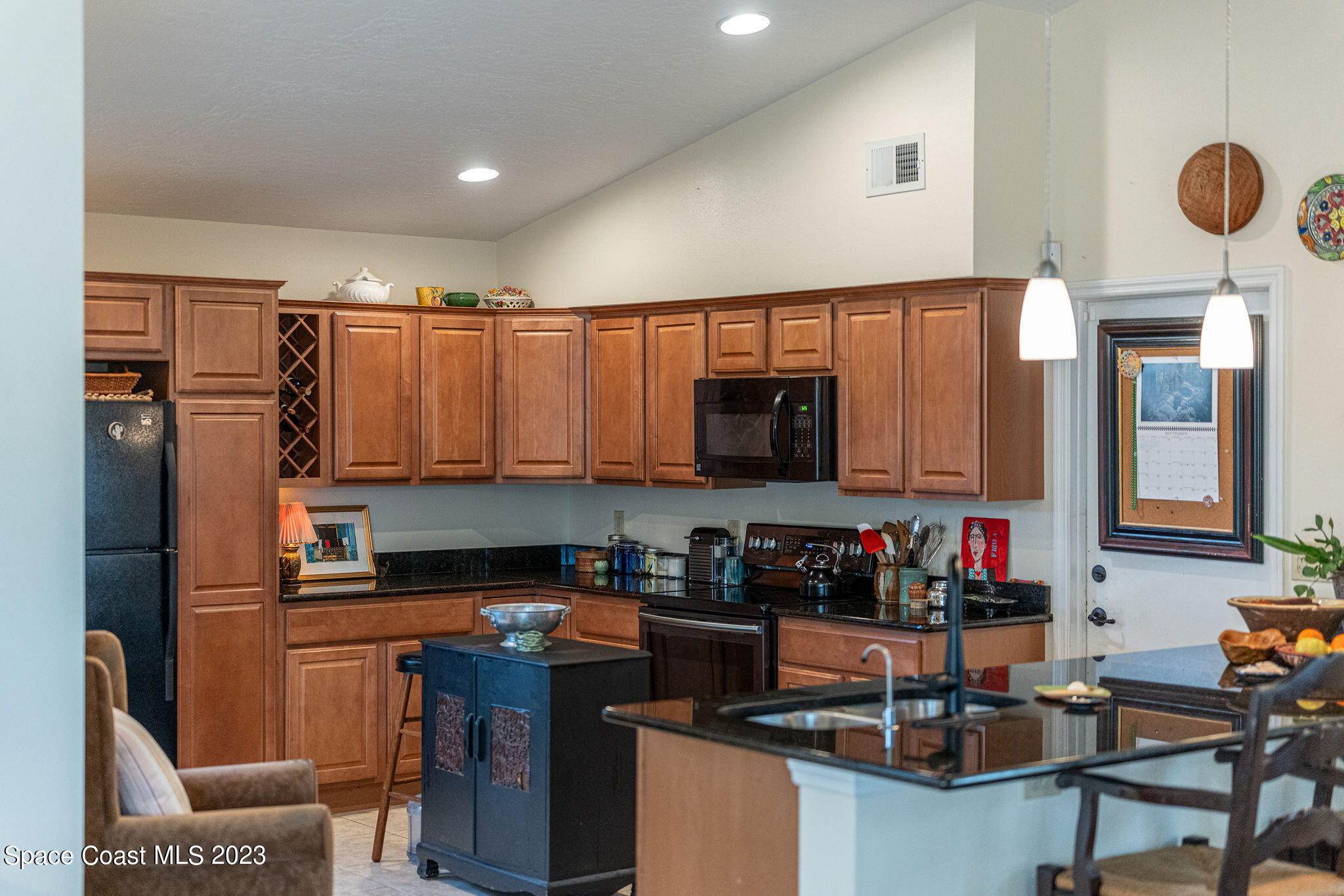 440 Maple Bluff Circle Melbourne, FL 32940 - Photo 53 of 92 a kitchen with stainless steel appliances granite countertop a stove top oven a sink dishwasher and cabinets with wooden floor