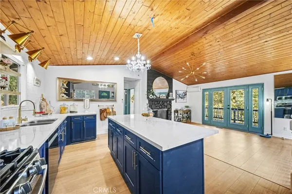 a large kitchen with kitchen island a large window a sink and stainless steel appliances