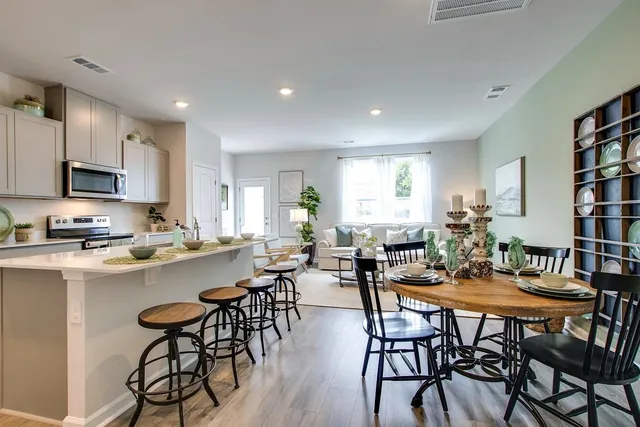 a view of a dining room with furniture and a kitchen