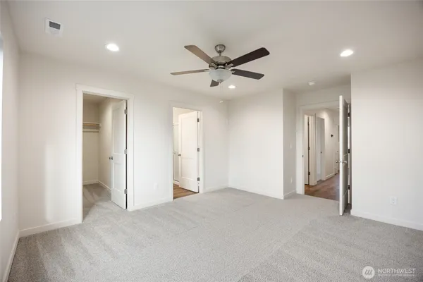 an empty room with windows and fan