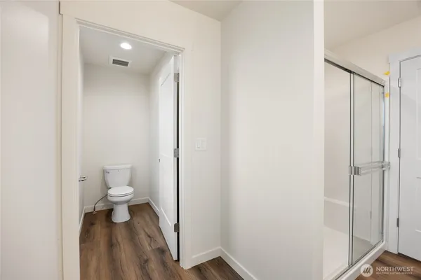 a spacious bathroom with a granite countertop sink a toilet and a shower