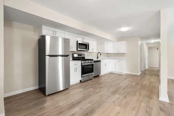 a kitchen with a refrigerator and a stove top oven