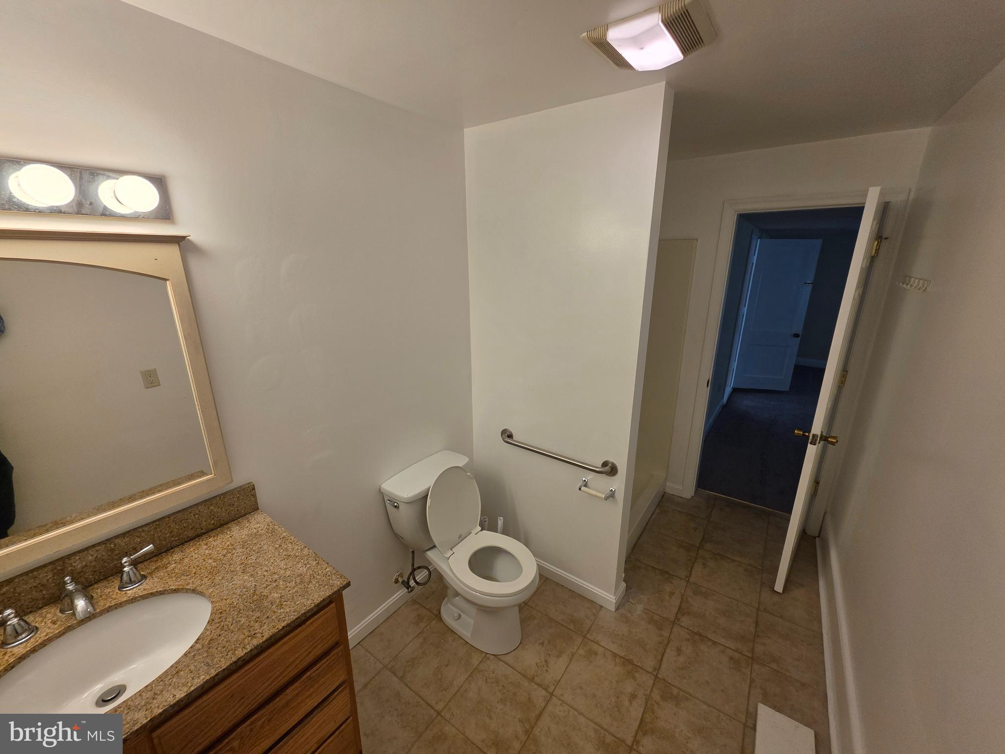 2318 Forrest Avenue Dover, DE 19904 - Photo 11 of 12 a bathroom with a granite countertop sink toilet and mirror