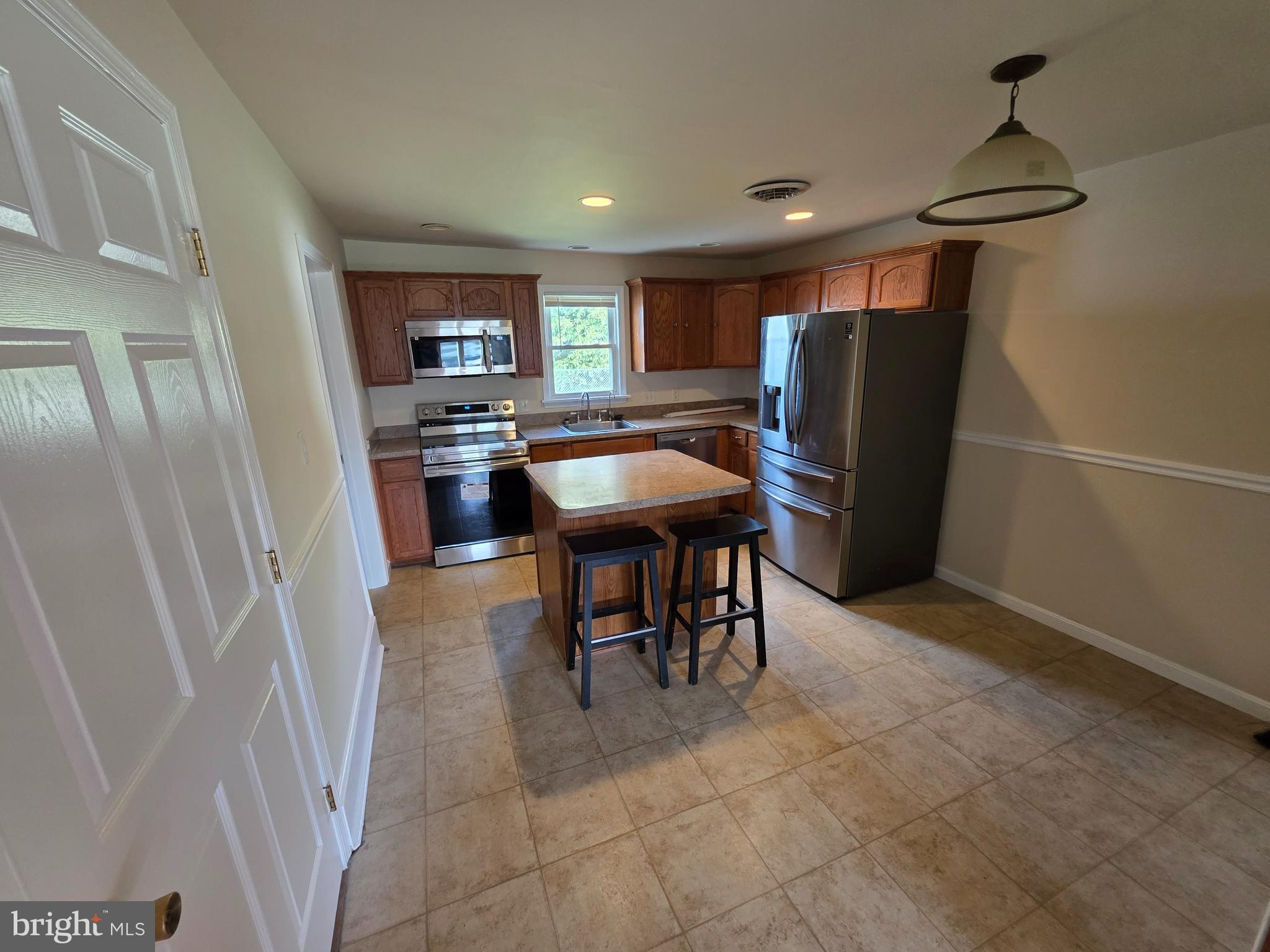 2318 Forrest Avenue Dover, DE 19904 - Photo 5 of 12 a kitchen with stainless steel appliances granite countertop furniture a refrigerator a sink a stove a dining table and chairs