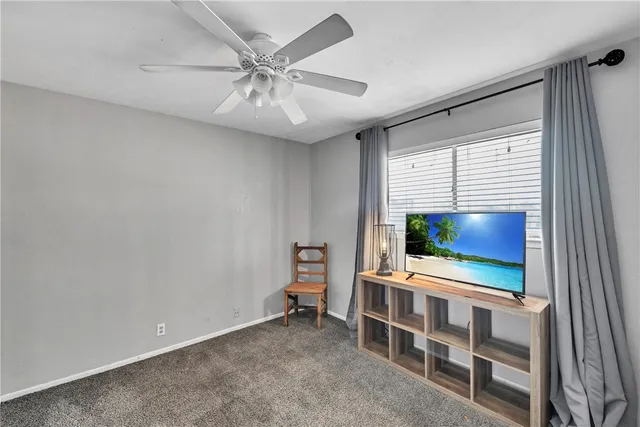 an empty room with a chandelier fan and a workspace
