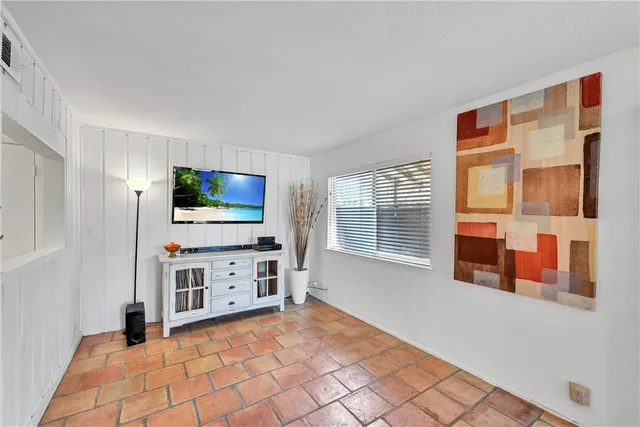 a view of a livingroom with furniture cabinet flat screen tv and windows