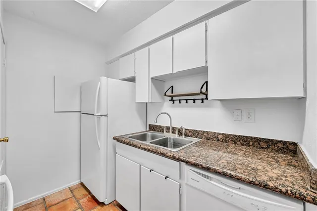 a kitchen with granite countertop a sink stainless steel appliances and cabinets
