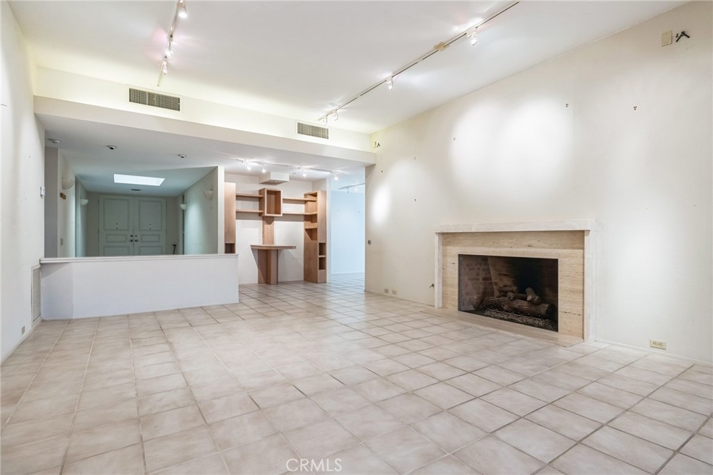 1 Radcliff Court Rancho Mirage, CA 92270 - Photo 23 of 52 an empty room with a fireplace and chandelier