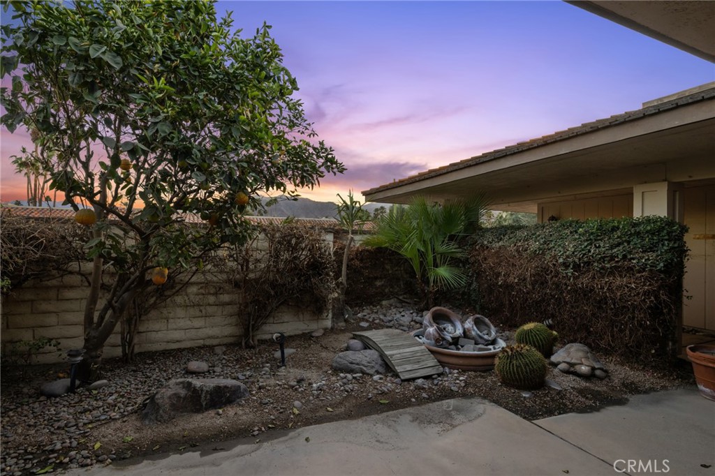 1 Radcliff Court Rancho Mirage, CA 92270 - Photo 8 of 52 a backyard of a house with fountain table and chairs under an umbrella