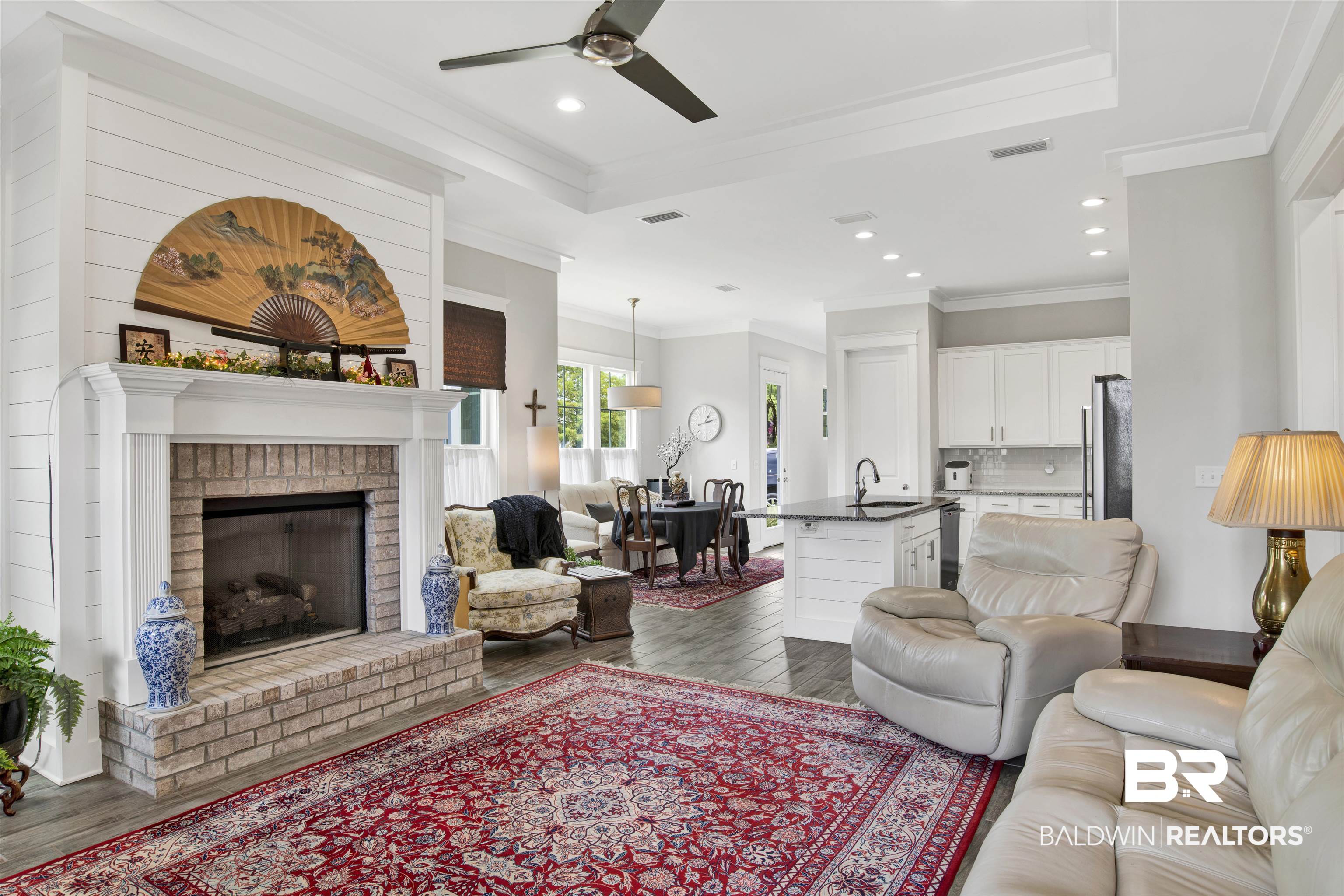23893 Cypress Crossing Orange Beach, AL 36561 - Photo 4 of 22 Living area featuring dark wood finished floors, ceiling fan, ornamental molding, a brick fireplace, and recessed lighting