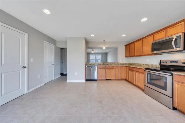 a large kitchen with stainless steel appliances granite countertop a stove a sink and a refrigerator