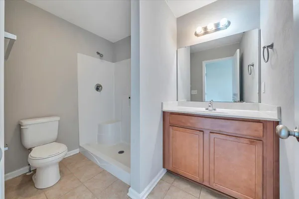 a bathroom with a toilet a sink a mirror and a shower