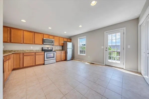 a open kitchen with stainless steel appliances granite countertop a stove top oven a sink dishwasher and a refrigerator with wooden floor