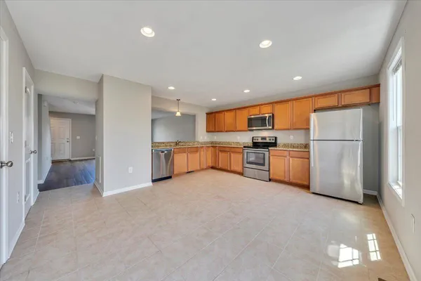a kitchen with stainless steel appliances granite countertop a refrigerator and a stove top oven