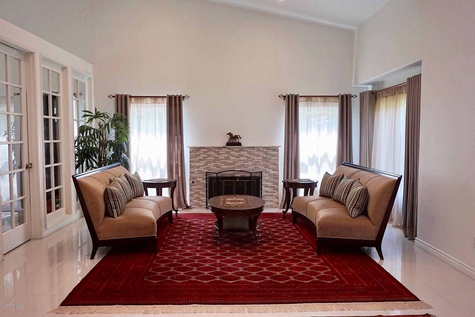 12448 Spring Creek Road Moorpark, CA 93021 - Photo 2 of 19 a living room with furniture a rug and a fireplace