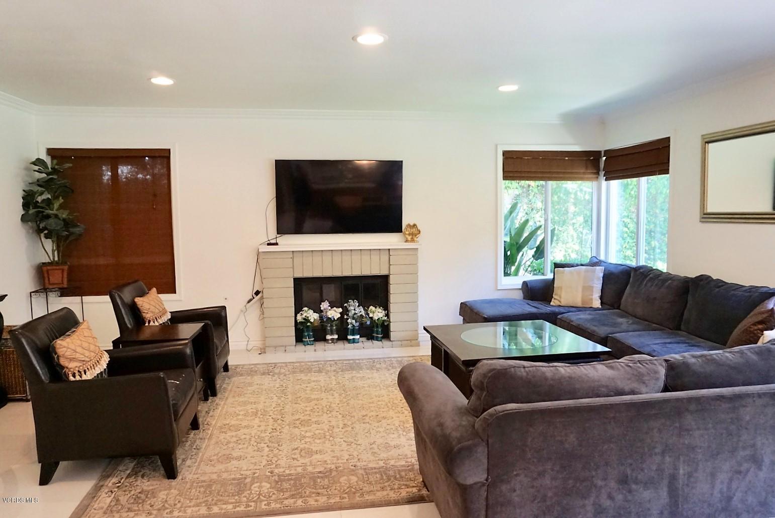 12448 Spring Creek Road Moorpark, CA 93021 - Photo 12 of 19 a living room with furniture a flat screen tv and a fireplace