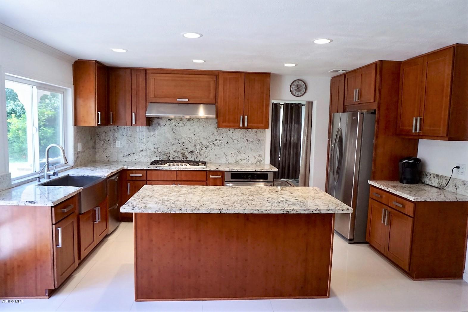 12448 Spring Creek Road Moorpark, CA 93021 - Photo 5 of 19 a kitchen with stainless steel appliances granite countertop wooden cabinets a stove and a refrigerator