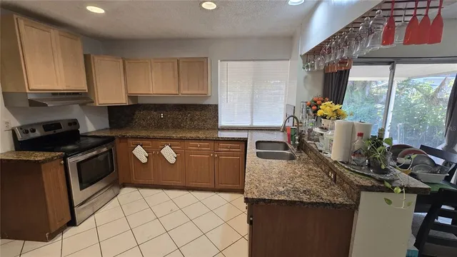 a kitchen with granite countertop a stove a sink and a cabinets
