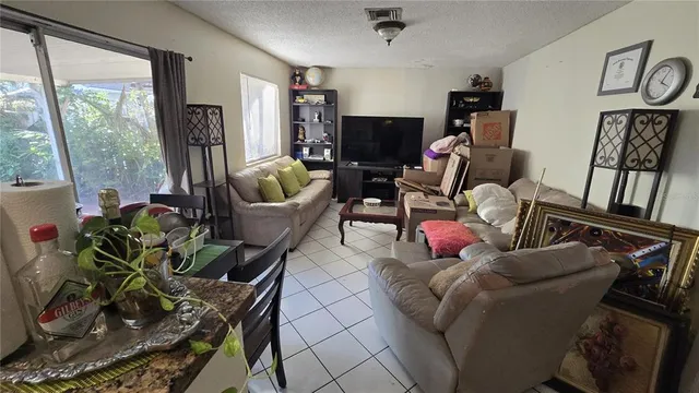 a living room with furniture a flat screen tv and a floor to ceiling window