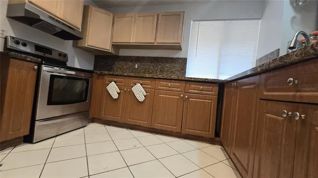 a kitchen with stainless steel appliances granite countertop a refrigerator and a stove