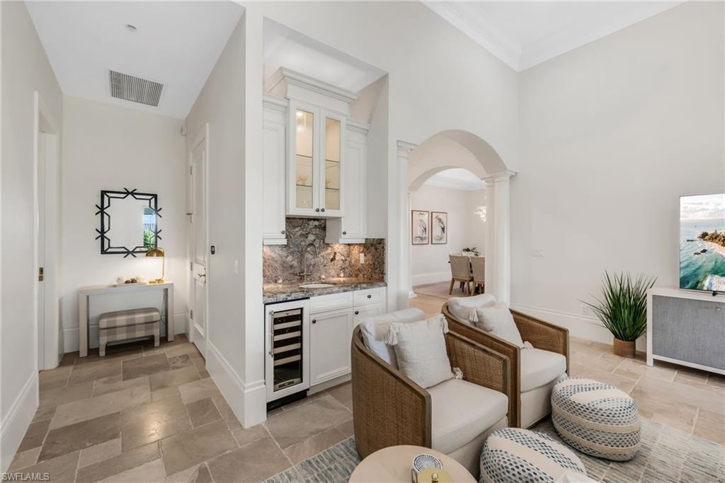 2323 Tradition Way, Unit 201 Naples, FL 34105 - Photo 12 of 48 The large living room has a custom bar, with guest powder room behind it, and a guest room to the left.