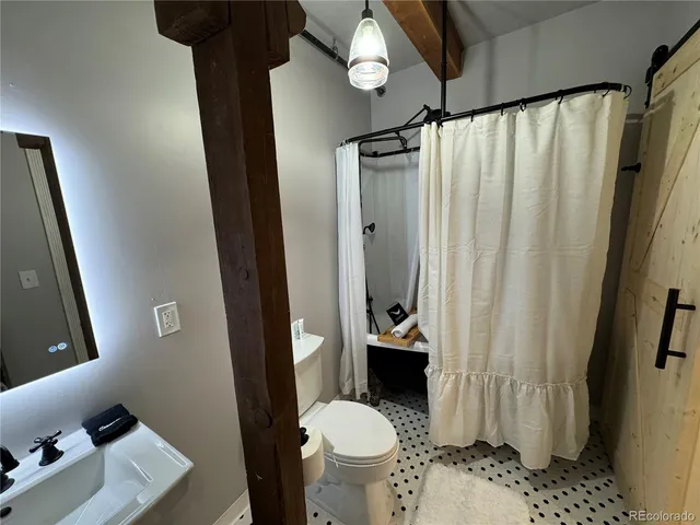 a bathroom with a sink toilet and a mirror