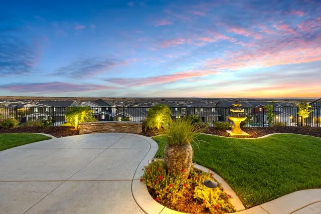 a front view of a house with a garden and yard