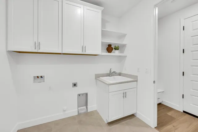 a kitchen with granite countertop a stove and white cabinets