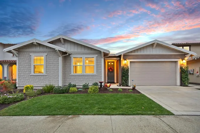 a bedroom with a large bed chandelier and a window