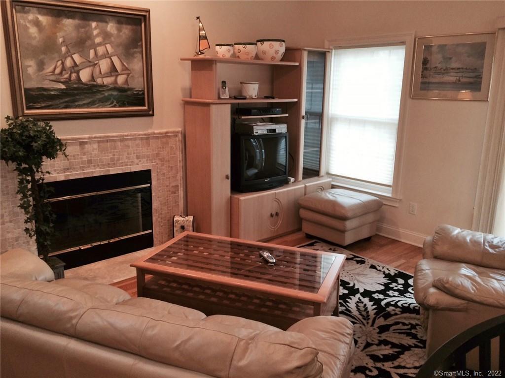 57 Harbor Avenue Madison, CT 06443 - Photo 4 of 16 a living room with furniture a flat screen tv and a fireplace