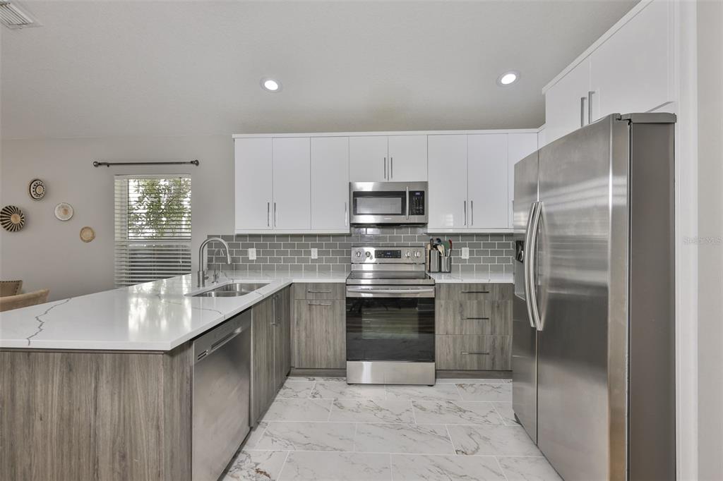 2331 West Chestnut Street Tampa, FL 33607 - Photo 12 of 34 a kitchen with stainless steel appliances granite countertop a refrigerator sink and stove