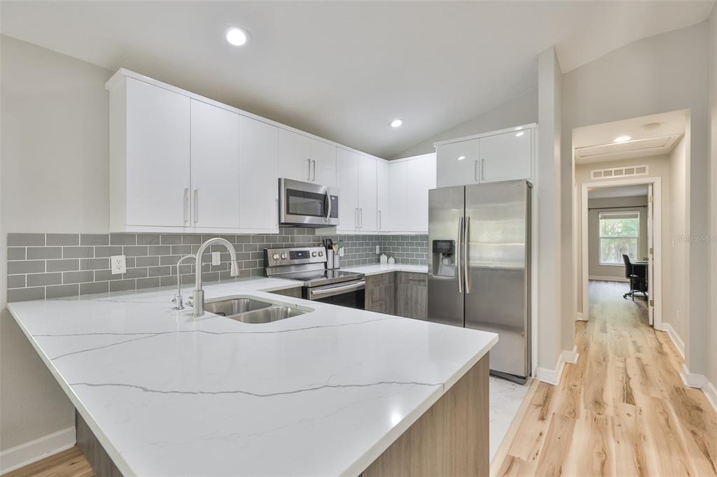 2331 West Chestnut Street Tampa, FL 33607 - Photo 15 of 34 a kitchen with stainless steel appliances granite countertop a sink a stove and a refrigerator