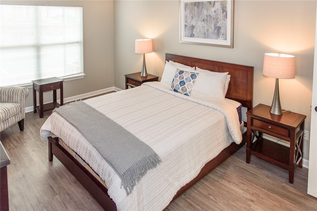 1260 Lehigh Station Road, Unit 1104 Henrietta, NY 14467 - Photo 7 of 14 Typical primary bedroom suite with plank flooring