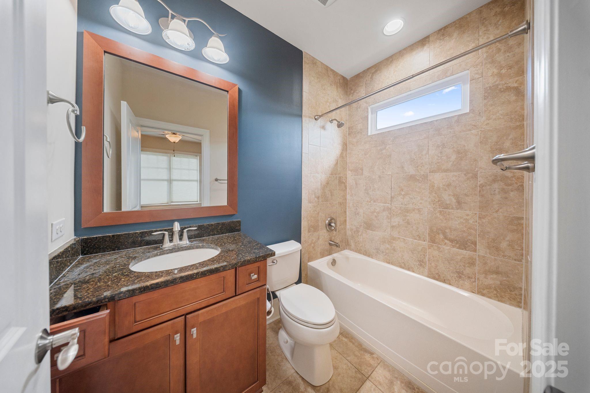 2051 Brawley School Road Mooresville, NC 28117 - Photo 30 of 47 a bathroom with a granite countertop sink toilet mirror vanity and bathtub